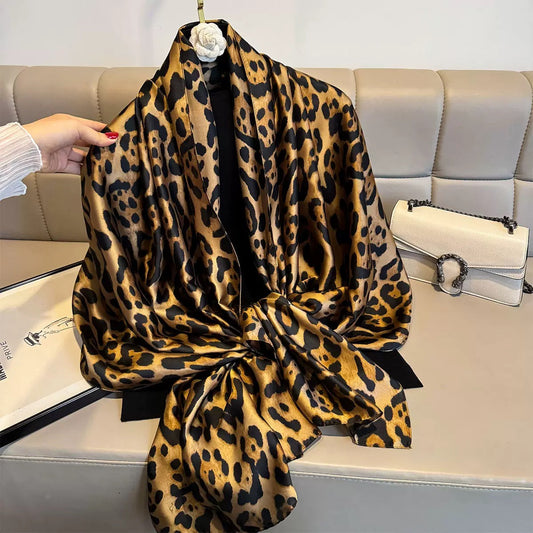Leopard print scarf draped over a sofa with a handbag in the background