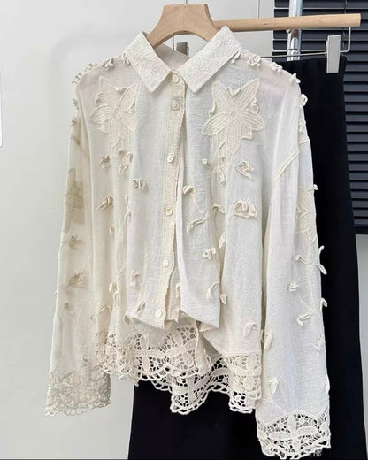 White embroidered blouse on a hanger against a white background
