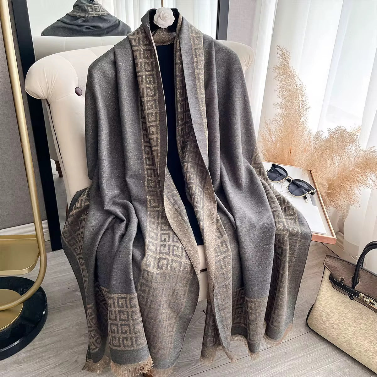 Gray patterned scarf draped over a mannequin in a room with decor elements.