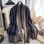 Black patterned scarf draped over a chair with a neutral background