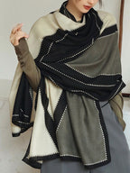 Person wearing a black, white, and gray patterned scarf