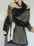 Person wearing a black, white, and gray patterned scarf on a white background
