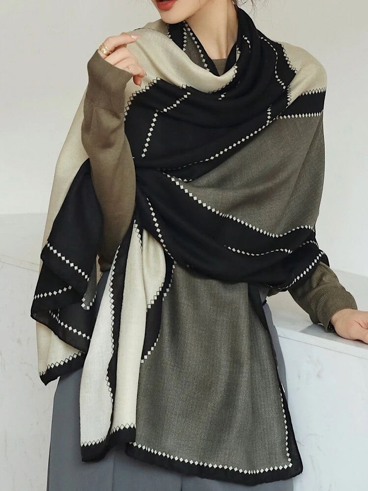 Person wearing a black, white, and gray patterned scarf on a white background