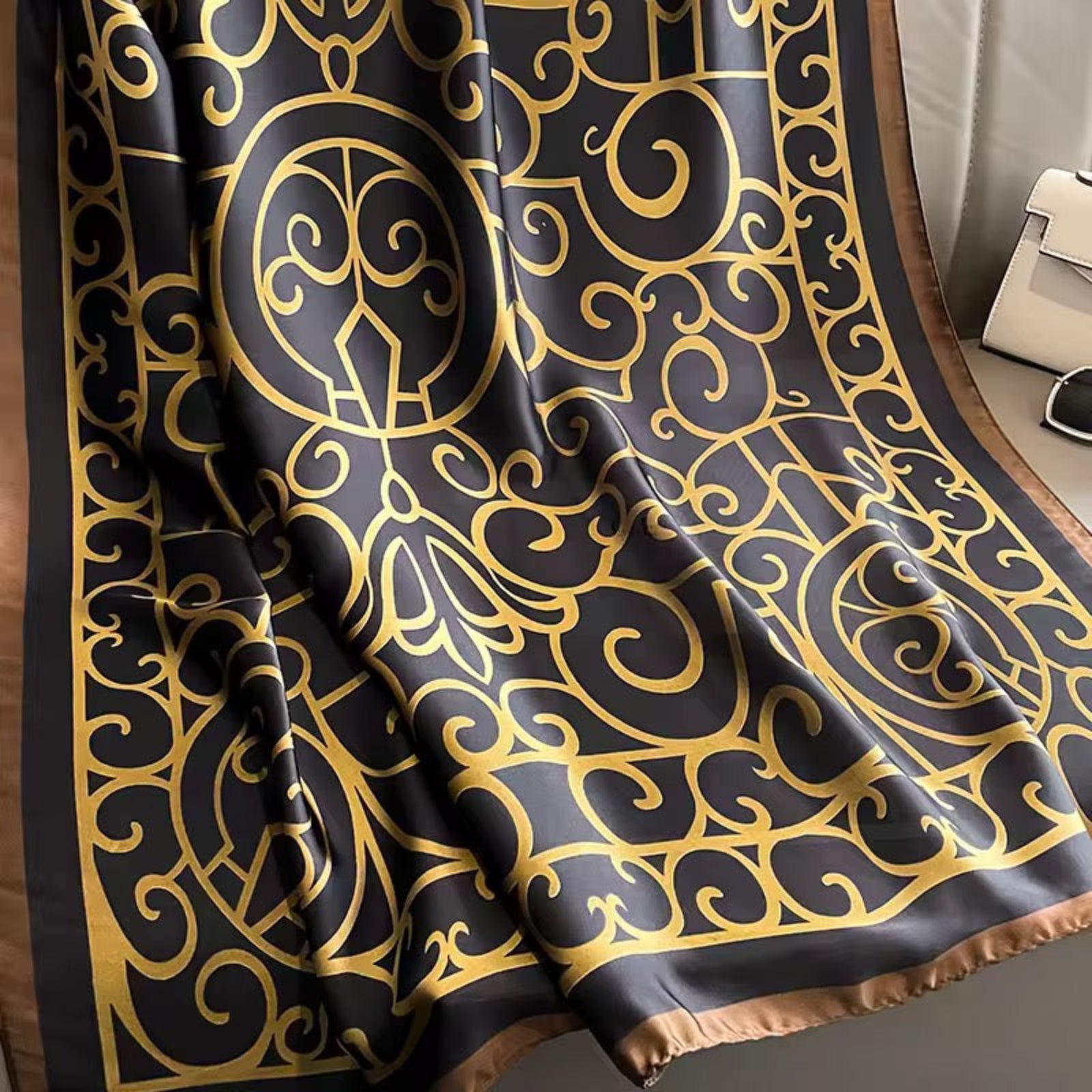 Black fabric with gold intricate pattern draped over a surface