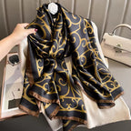 Black and gold patterned scarf held by a hand with a neutral background