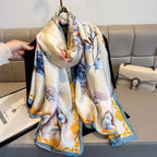 Colorful scarf with floral design held by a hand on a couch background
