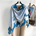 Blue and white patterned scarf draped over a mannequin with a magazine and handbag in the background.