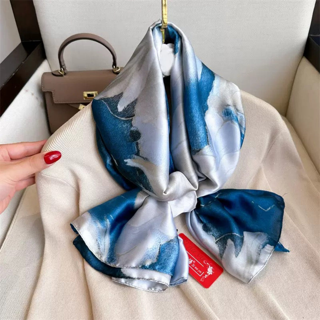 Blue and white patterned scarf with a red tag on a beige surface
