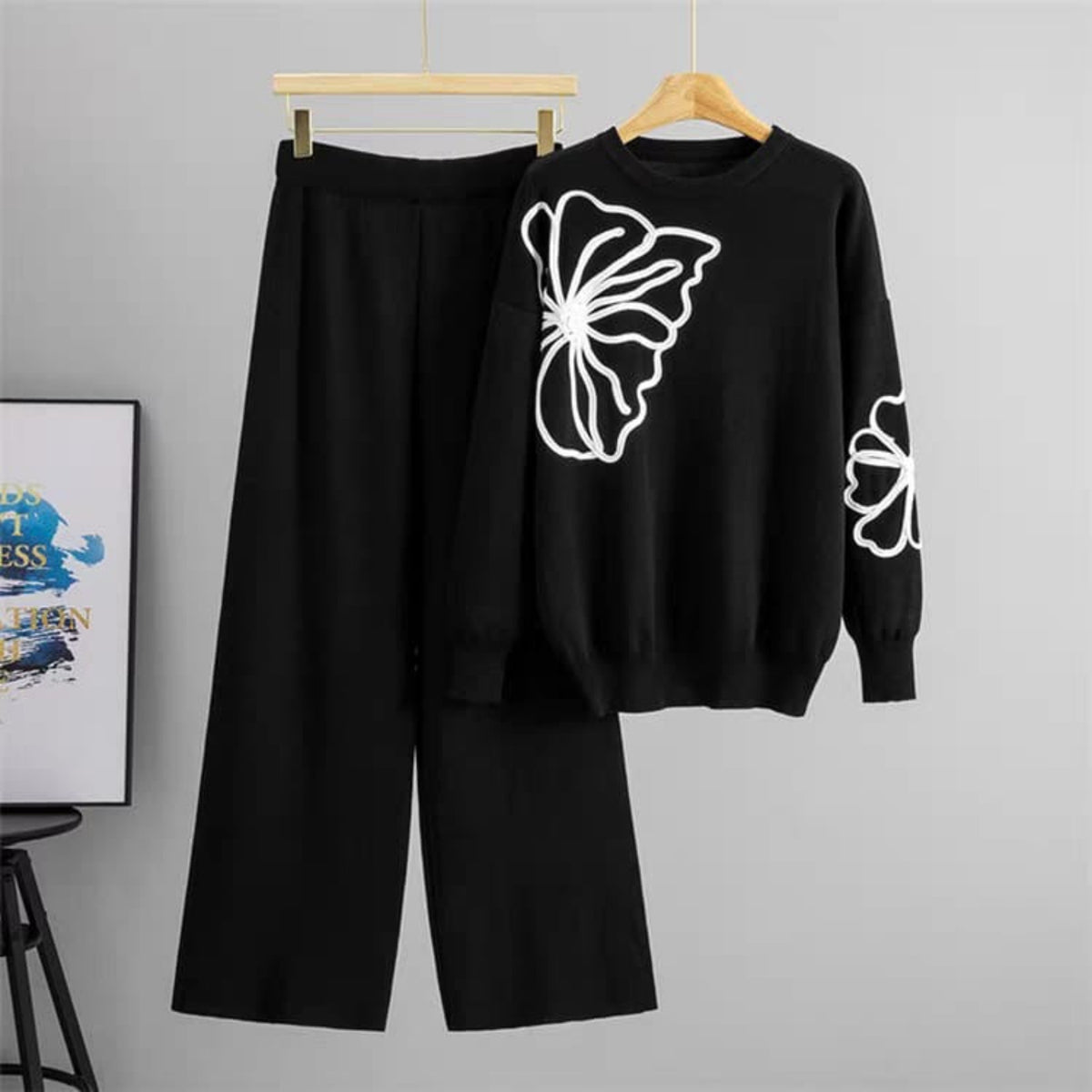 Black outfit with butterfly design on a gray background
