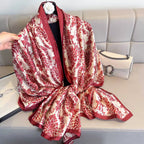 Red and white patterned scarf draped over a sofa with a handbag beside it.