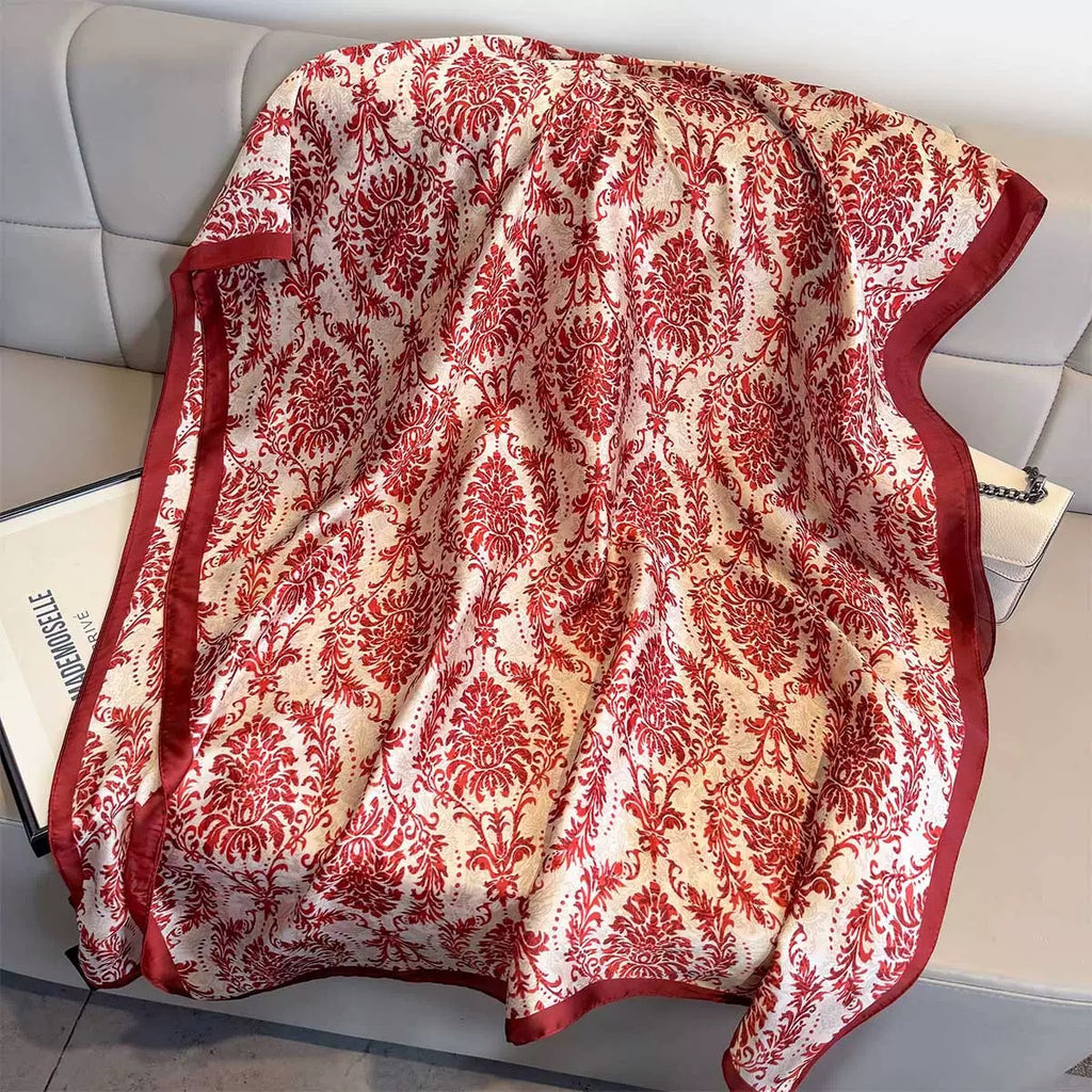 Red and white patterned scarf draped over a surface with a magazine underneath.