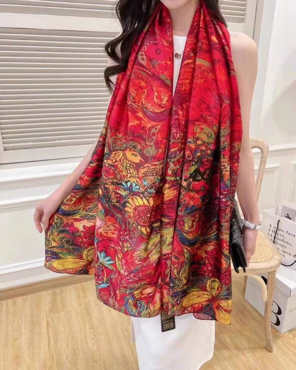 Woman wearing Crimson Royale Printed Silk Stole showing how the vibrant multicolour print and deep crimson satin silk drapes when styled
