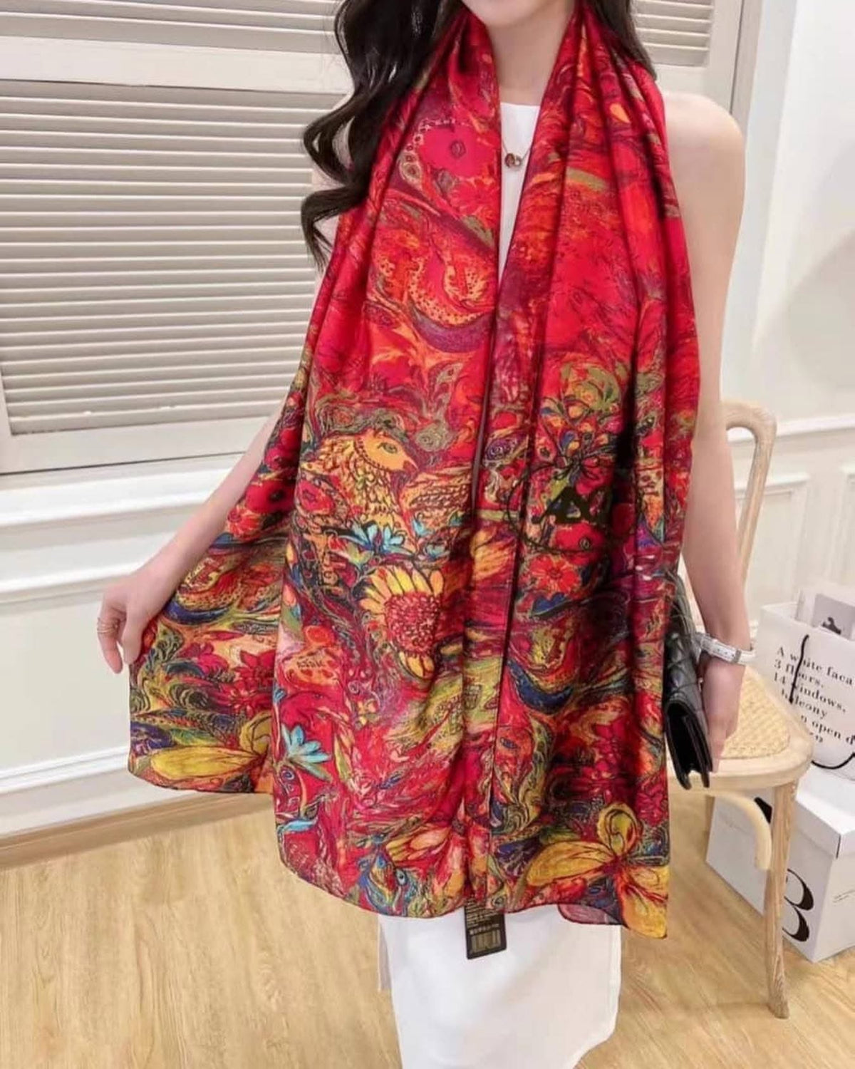 Woman wearing Crimson Royale Printed Silk Stole showing how the vibrant multicolour print and deep crimson satin silk drapes when styled
