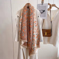 Floral scarf draped over a coat with a handbag on a white background