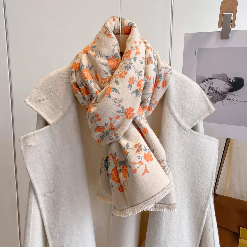 Floral patterned scarf draped over a white coat with a neutral background