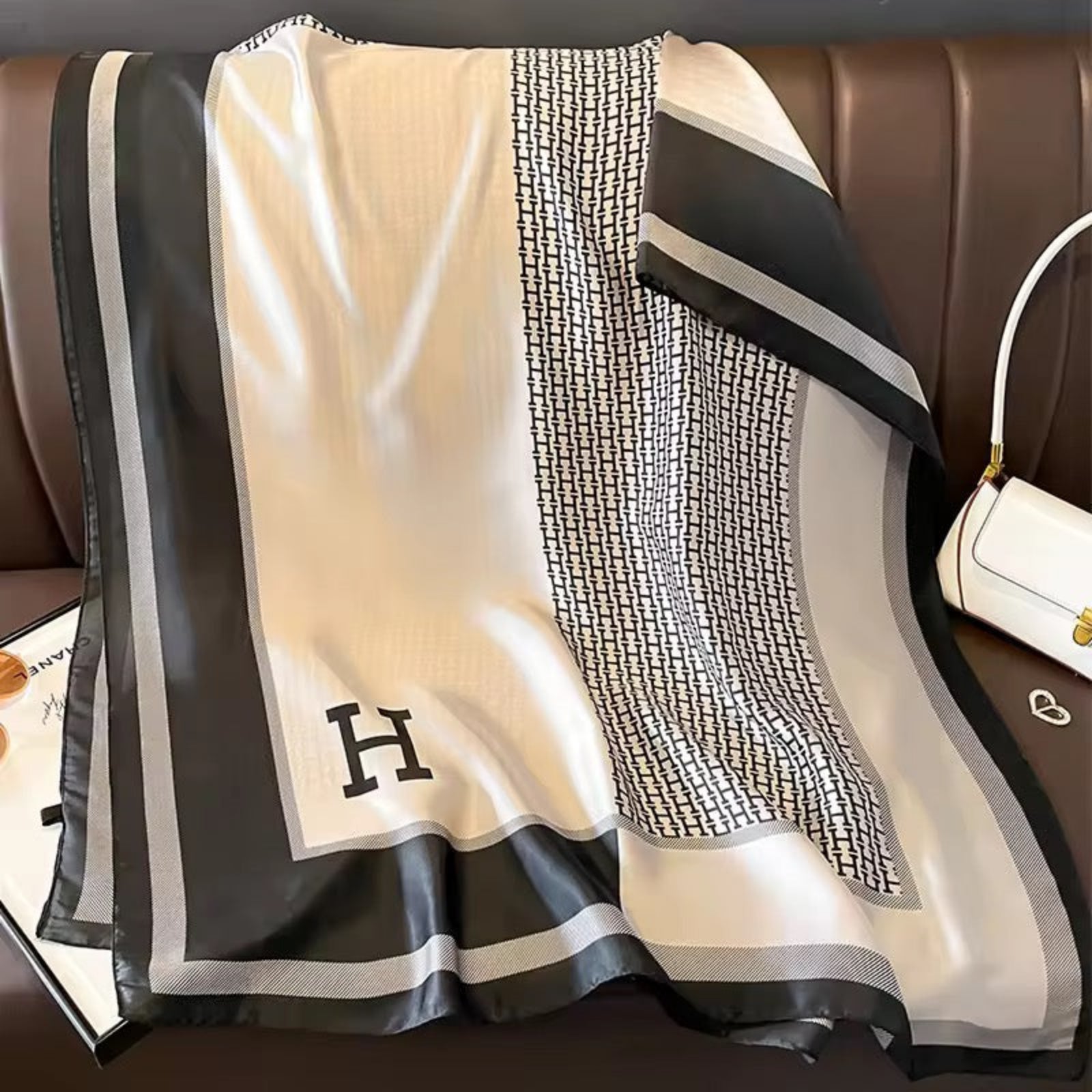 Black and white patterned scarf with a letter 'H' on a brown surface