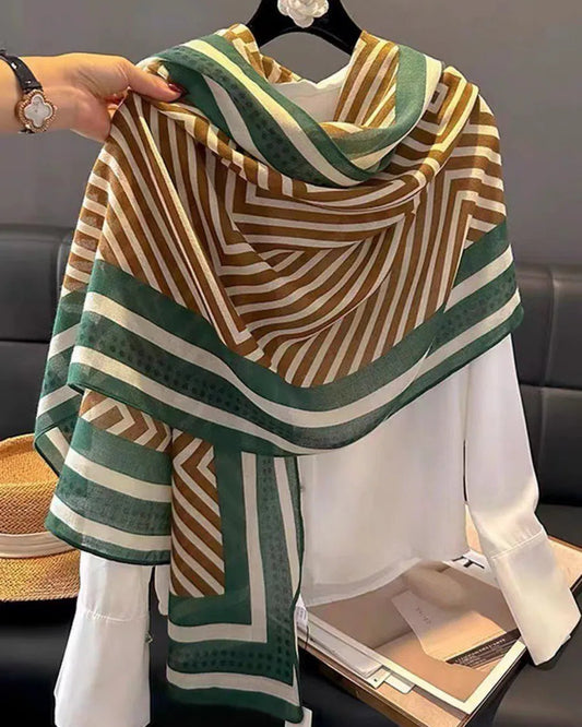 Striped scarf being held up with a neutral background