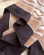 Detail shot of Hais striped stole showing deep espresso black border and camel stripe herringbone finish