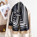 Black and white striped scarf draped over a beige jacket with a handbag and photo in the background.