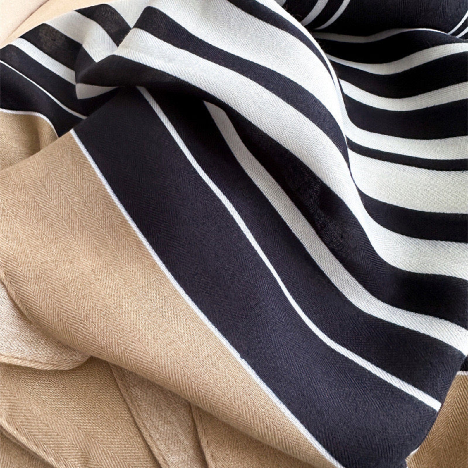Navy and white striped blanket draped over a beige surface