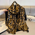 Leopard print scarf draped over a black garment against a neutral background