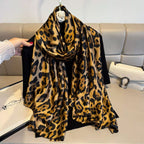 Leopard print scarf draped over a black garment against a neutral background