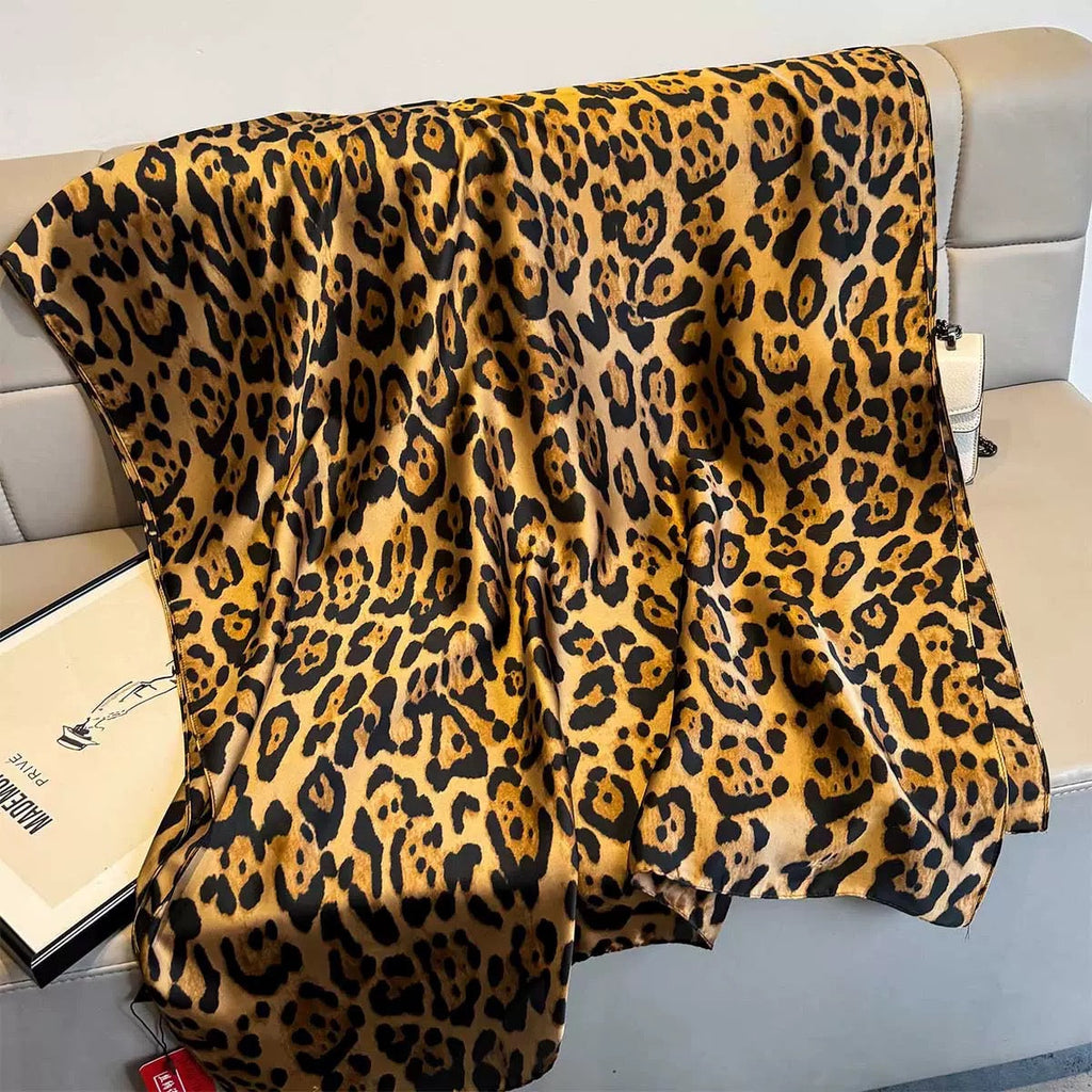 Leopard print blanket draped over a couch with a visible brand tag.