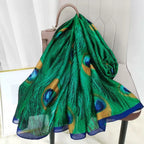 Green peacock feather patterned scarf draped over a chair with a neutral background