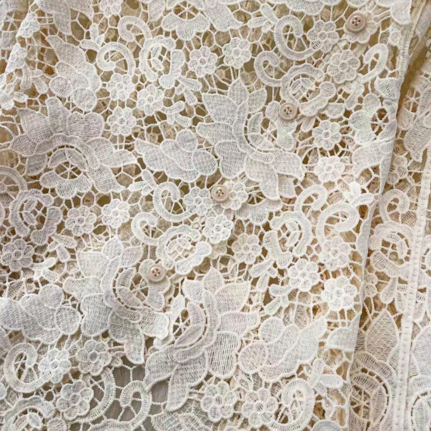 Detail shot of scalloped floral lace top button closure