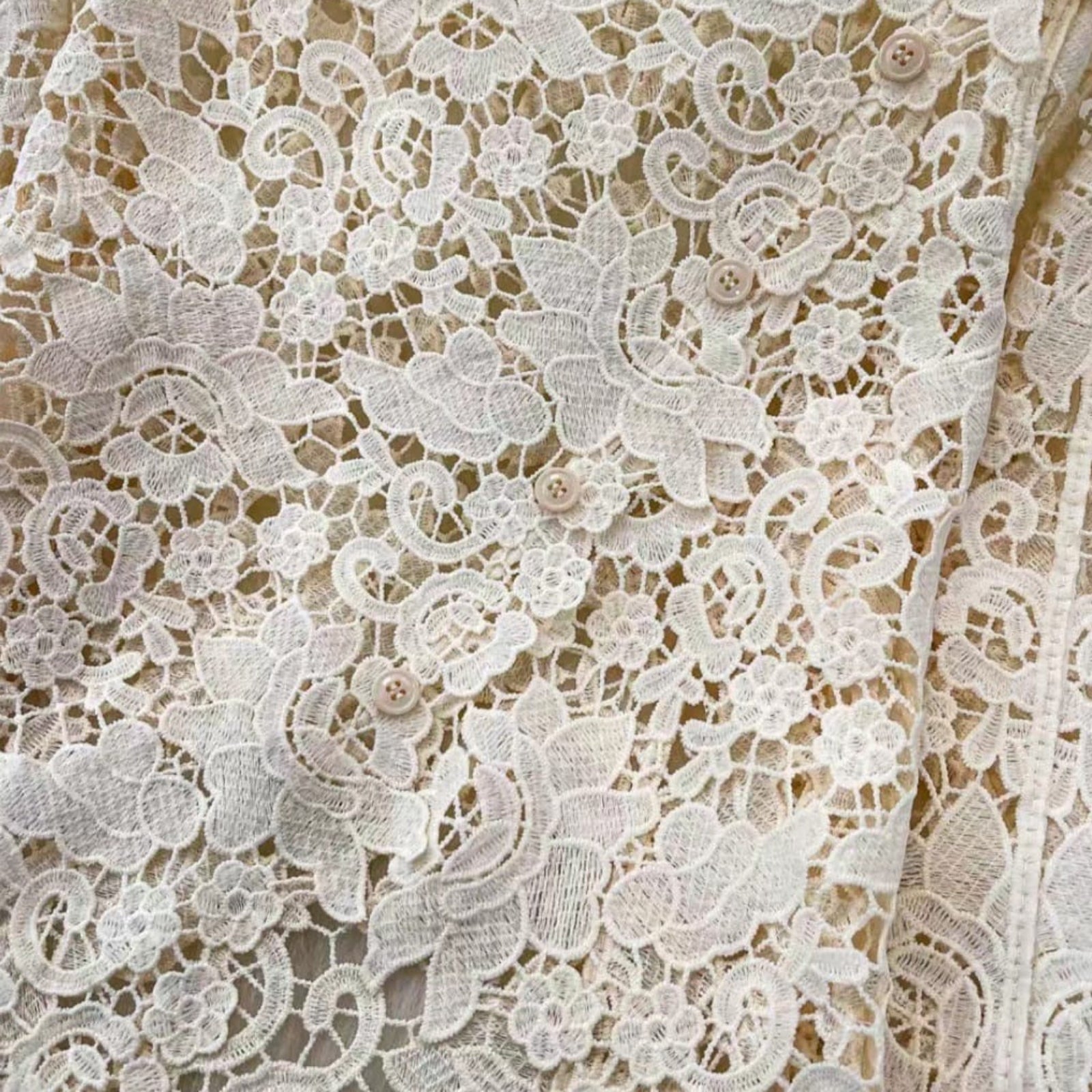 Detail shot of scalloped floral lace top button closure