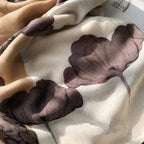 Close-up of a beige and brown floral patterned fabric with a brand label in the corner.