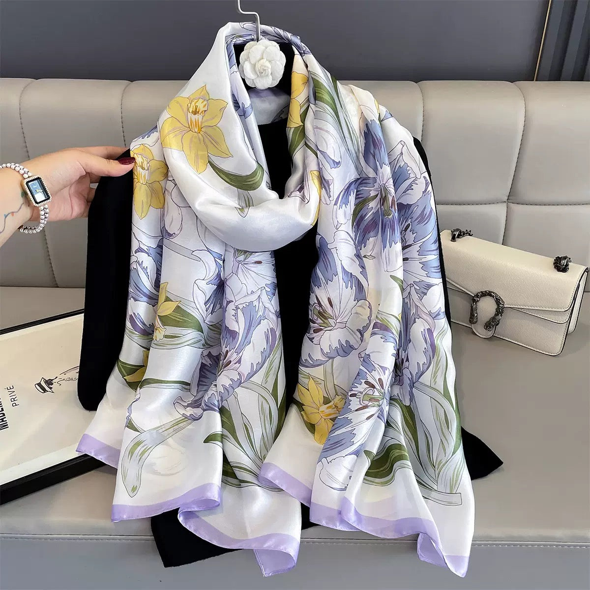 Floral patterned scarf on a mannequin against a gray sofa background