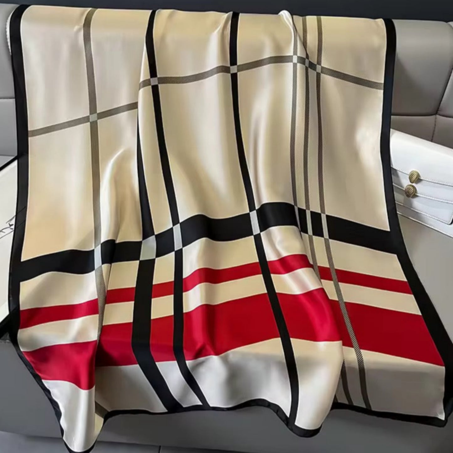 Checkered blanket with red, black, and beige pattern draped over a chair.