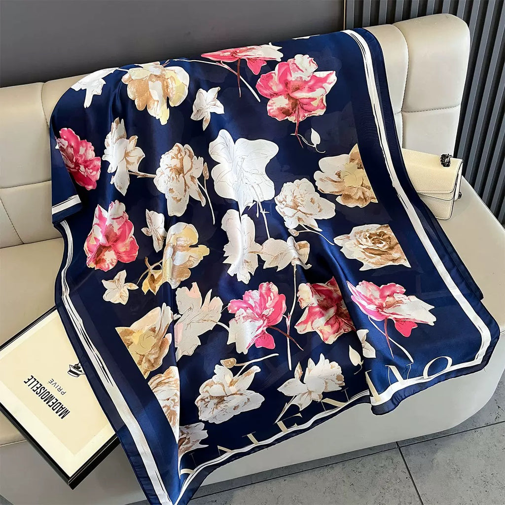 Floral-patterned blanket on a white couch with a visible brand name.