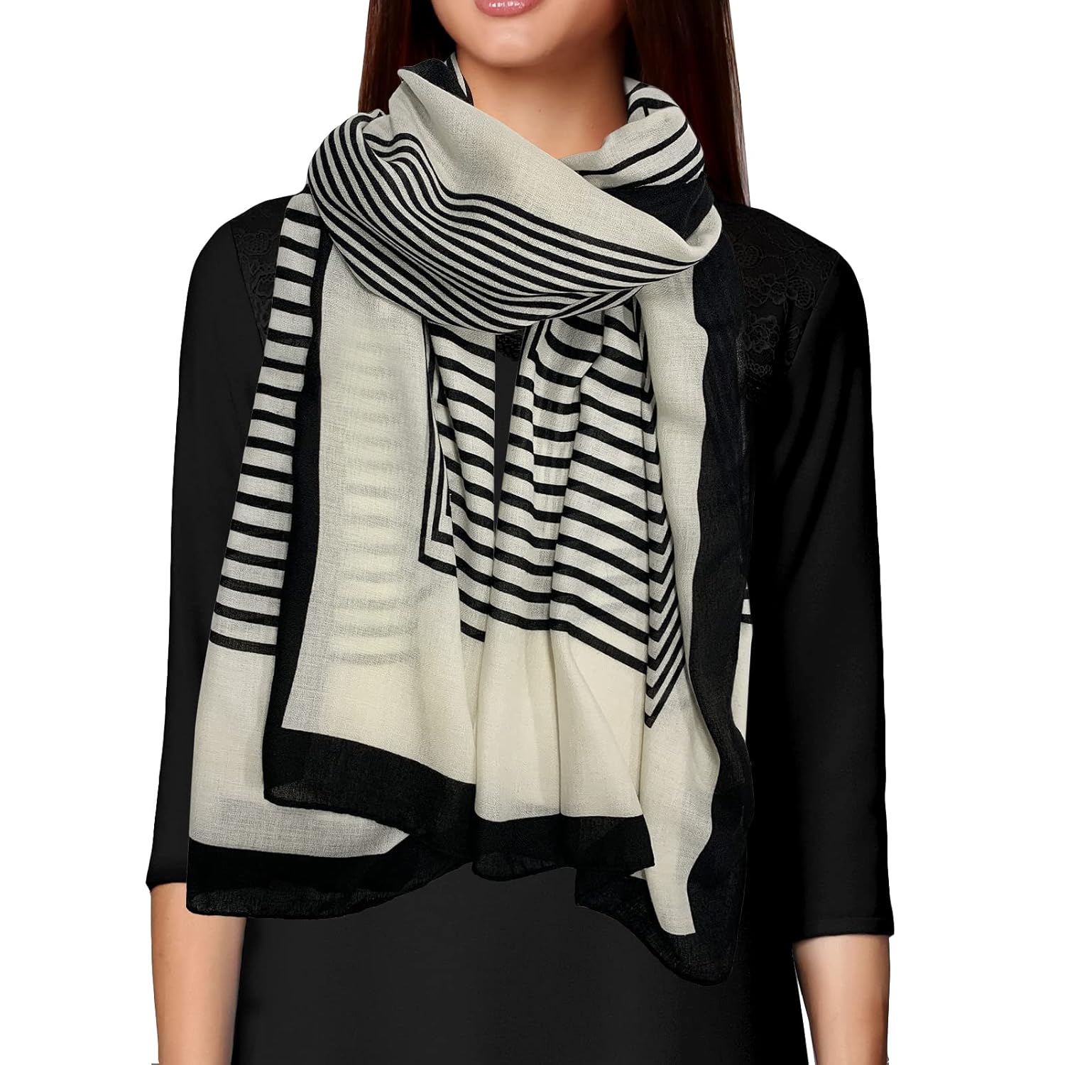 Person wearing a black and white striped scarf on a plain background