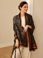 Woman wearing the  Paisley Print  Silk Scarf as an open-front wrap, showcasing the detailed paisley print and luxurious copper satin border for sophisticated everyday styling.