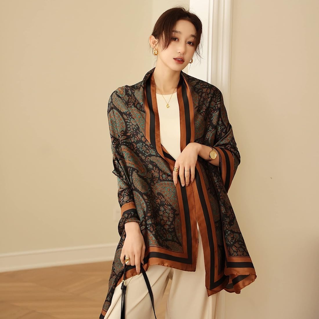 Woman wearing a patterned scarf in a neutral indoor setting