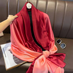 Red and pink gradient scarf on a hanger with sunglasses and magazine underneath.