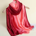 Red and pink gradient scarf on a hanger against a beige background