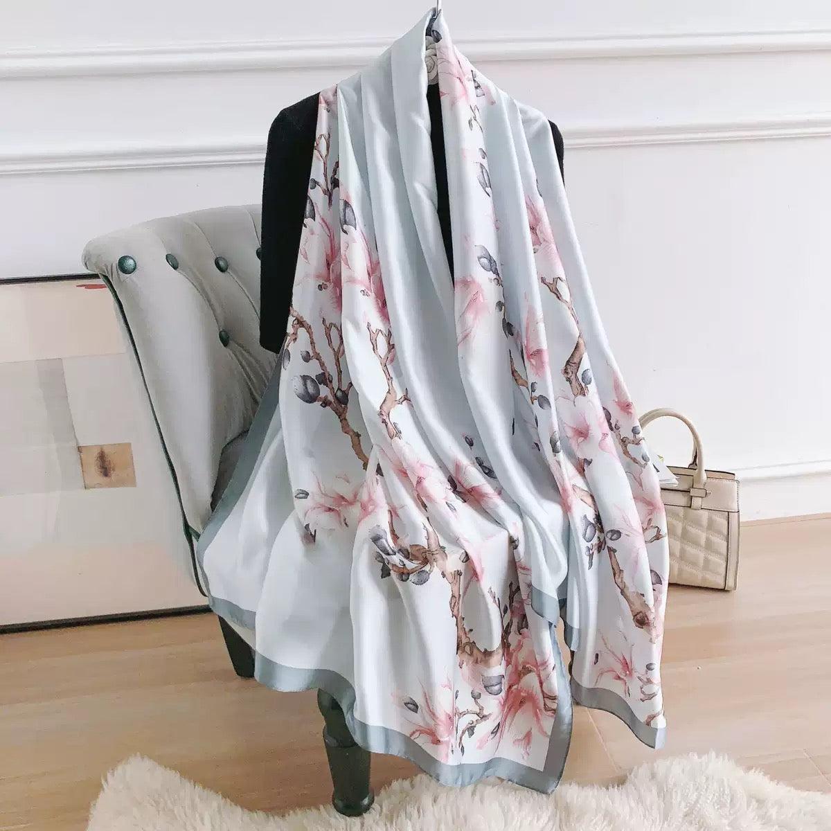 Floral scarf draped over a chair in a room with a neutral background