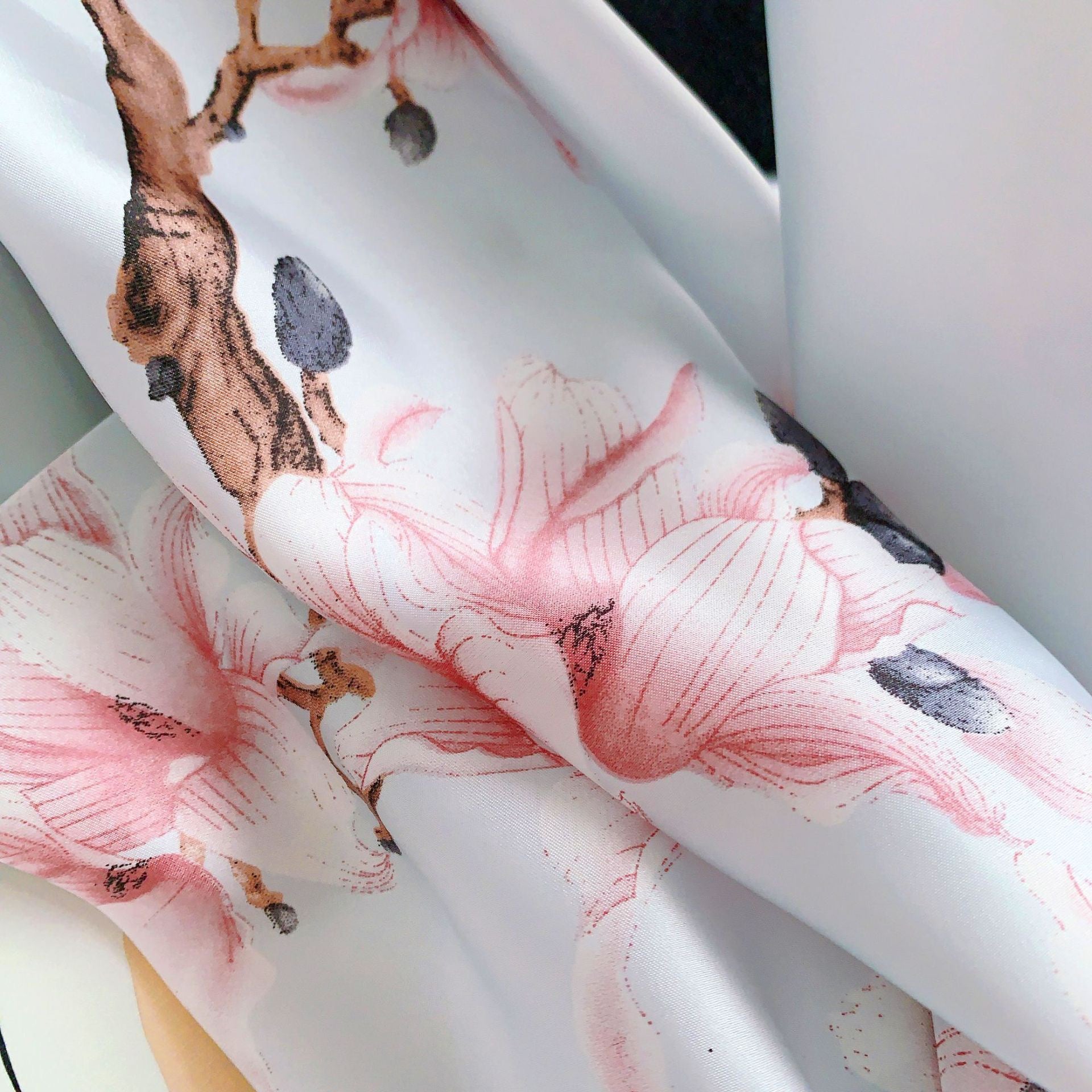 Roll of fabric with floral design on a white background