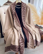 Beige shawl with leopard print border draped over a mannequin against a neutral background.