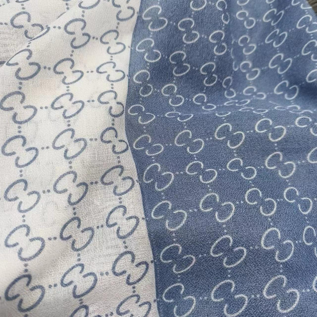 Close-up of fabric with a pattern of interlocking shapes on a white and blue background