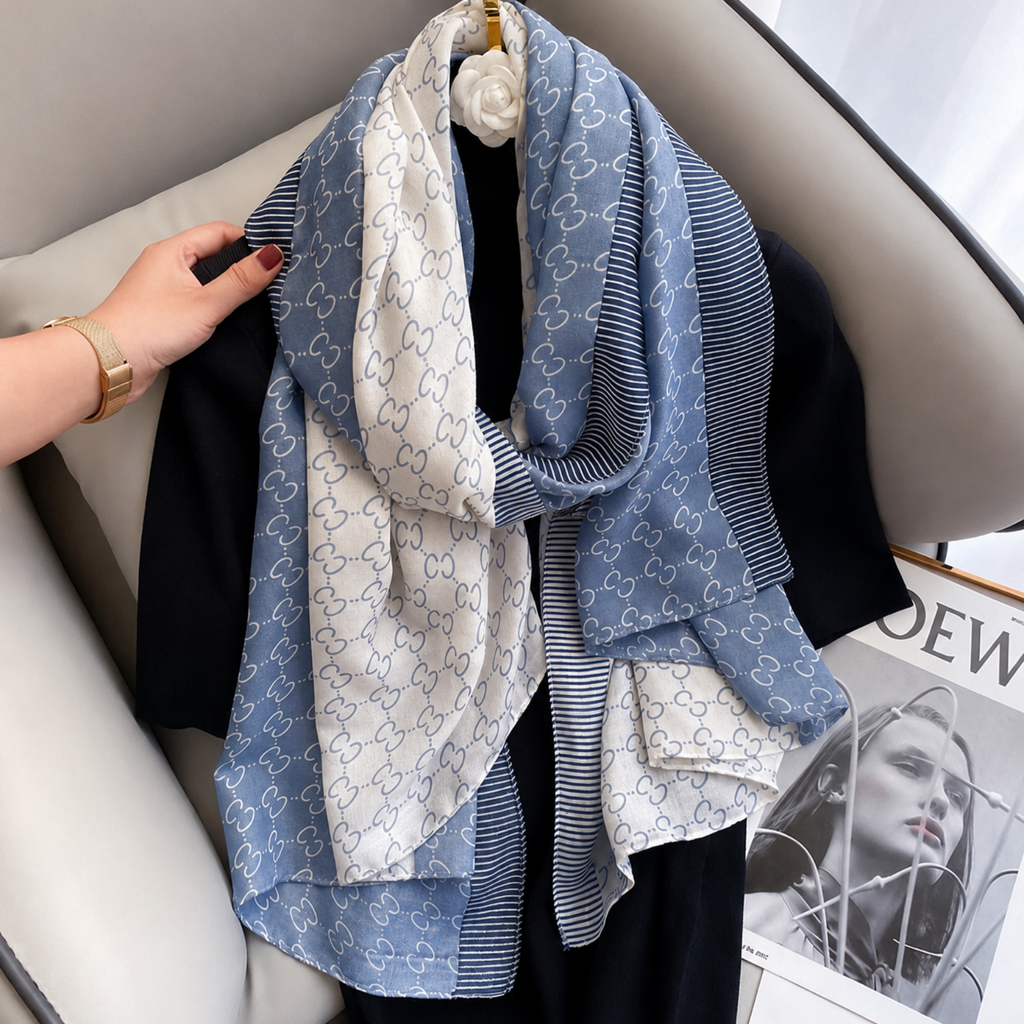 Blue and white patterned scarf draped over a car seat with a hand adjusting it.