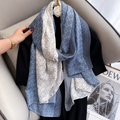 Blue and white patterned scarf draped over a car seat with a hand adjusting it.