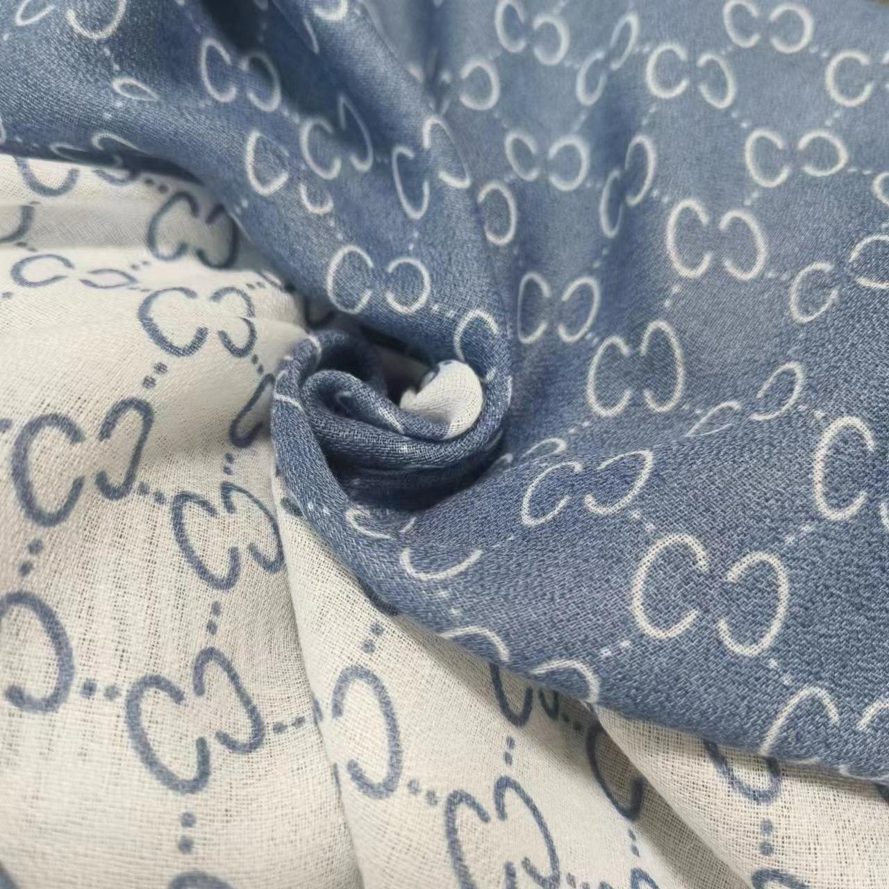 Close-up of fabric with a pattern of interlocking 'C' shapes in blue and beige.