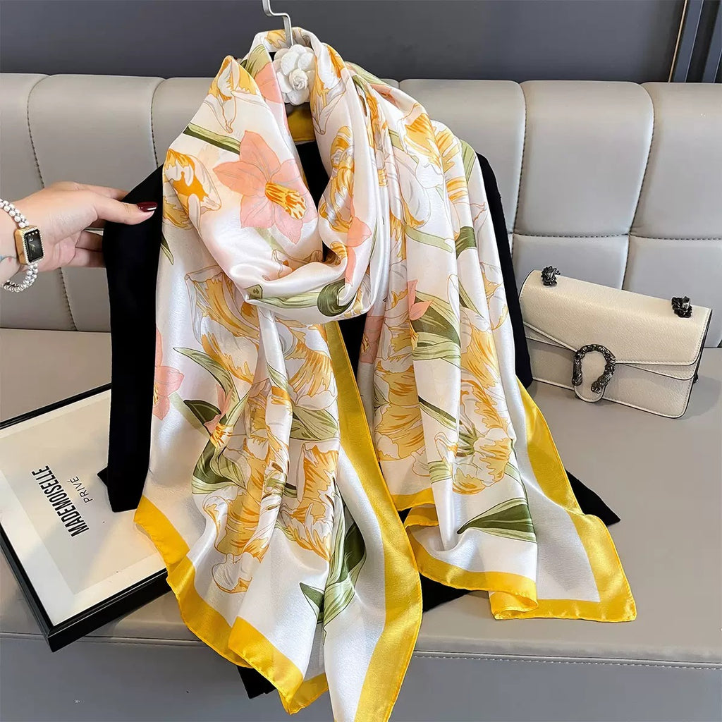 Floral patterned scarf draped over a sofa with a handbag and magazine in the background.