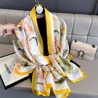 Floral scarf with yellow accents draped over a sofa, with a handbag in the background.