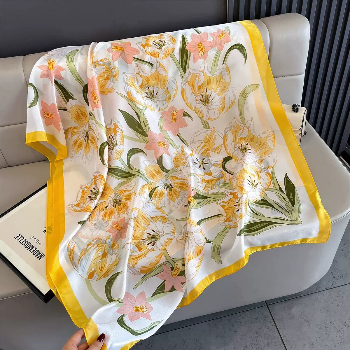 Floral patterned scarf draped over a chair with a visible brand name.