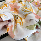 Floral patterned fabric held by a hand with red nail polish